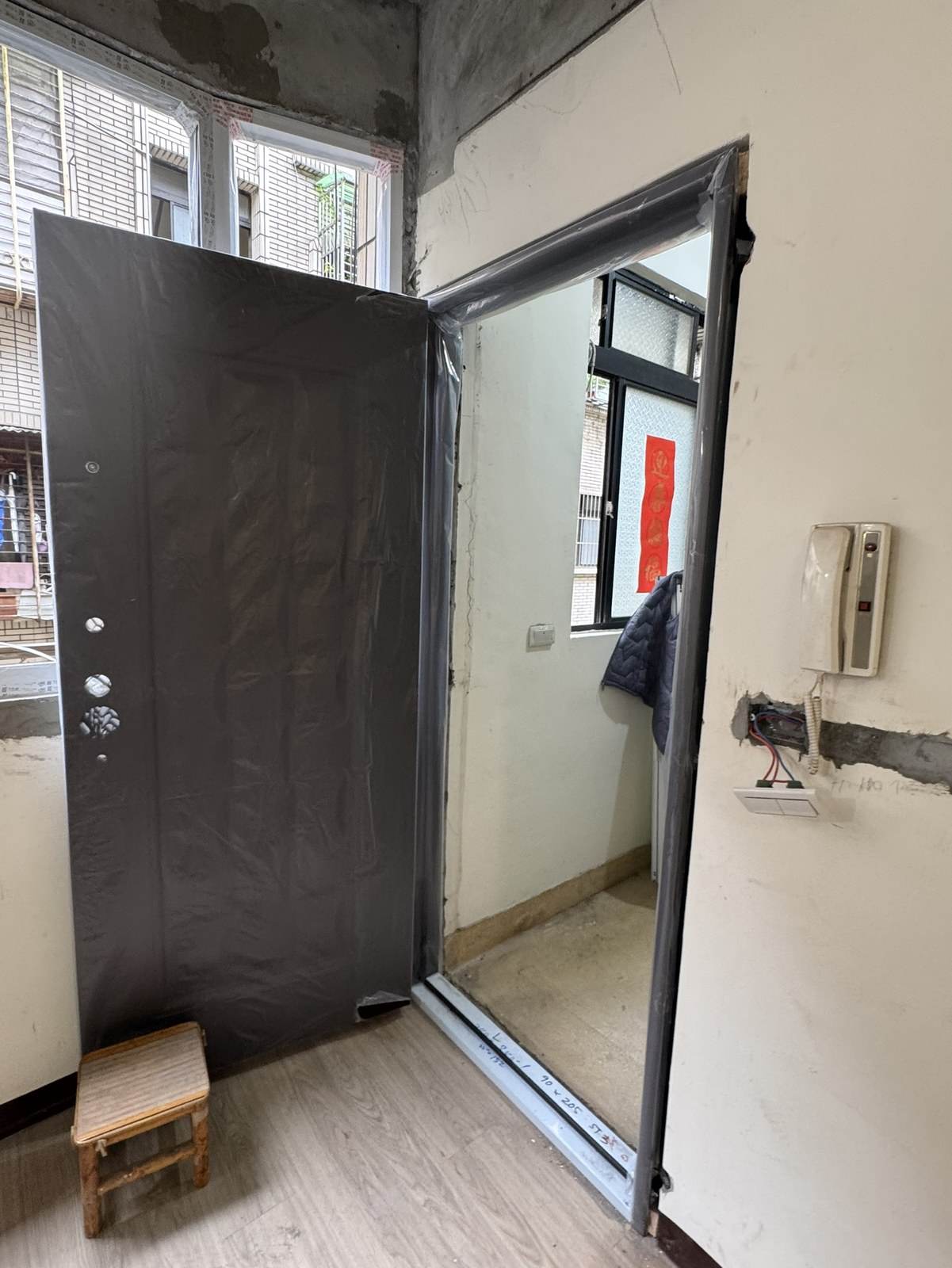 壓花門組610 安裝完成門打開的樣子:新門框與門檻已就位,門片開啟,門檻上還有手寫的尺寸
