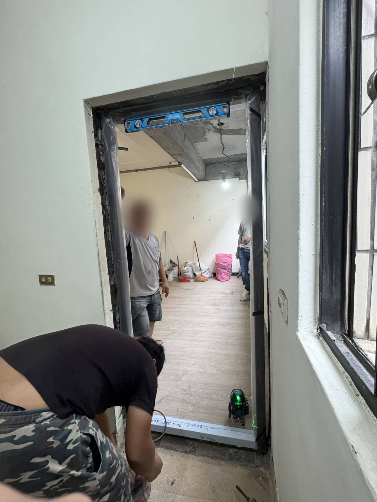 換門當天的玄關:舊框已拆、新門框剛立好,水平尺壓在上框,門片還沒掛上